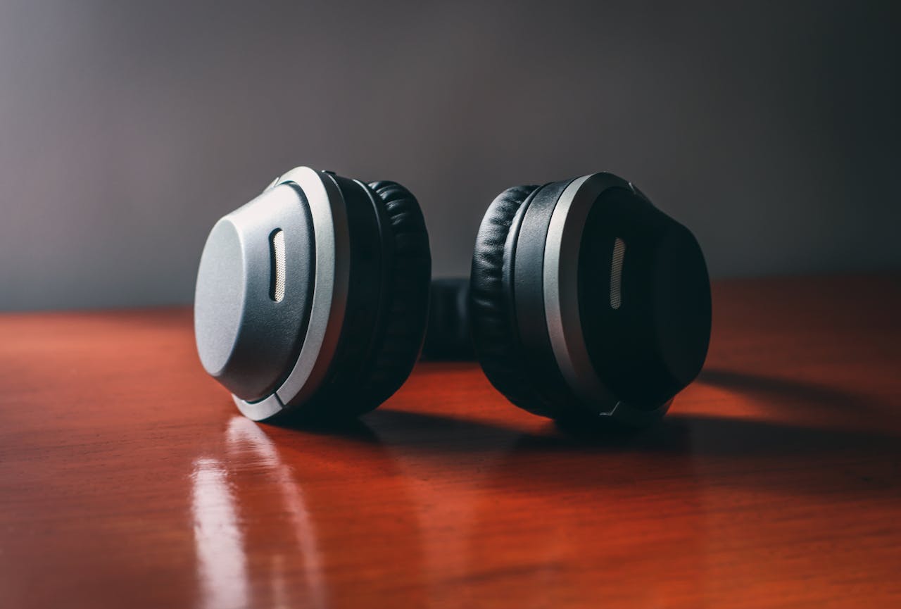 Close-up of sleek wireless headphones on a wooden surface, perfect for music enthusiasts.